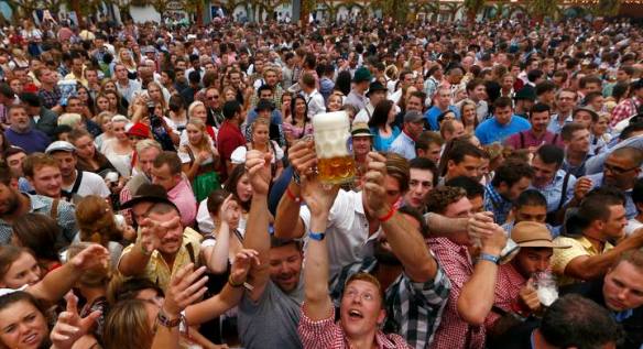 Visitors reach for one of the first mugs of beer after the tapping of the first barrel during the opening ceremony for 181st Oktoberfest in Munich